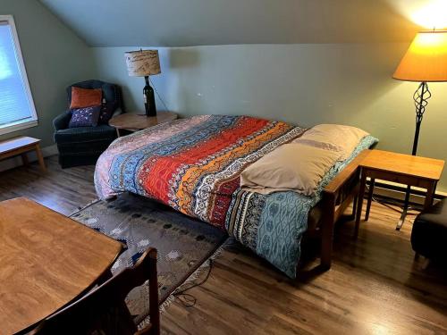 a bedroom with a bed and a table and a chair at Point Breeze Guest House in Pittsburgh