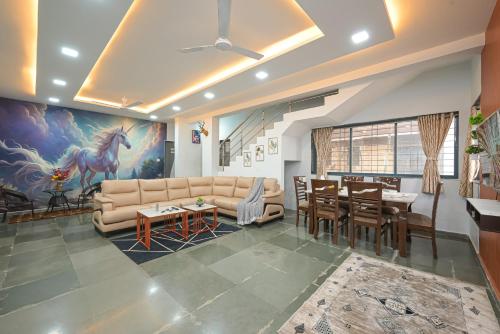 ein Wohnzimmer mit Sofa und Tisch in der Unterkunft ll EMPYREAN STAY ll 3BHK ll CELESTIAL UNICORN VILLA ll AC ll PRIVATE POOL ll LUXURY ll in Lonavla