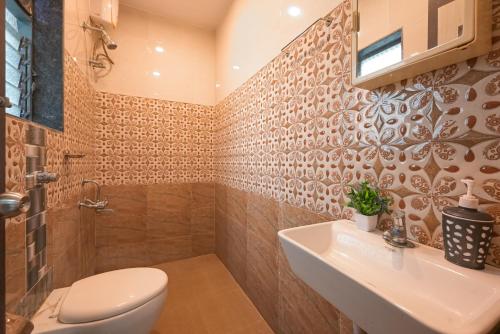 ein Badezimmer mit Toilette, Waschbecken und Dusche in der Unterkunft ll EMPYREAN STAY ll 3BHK ll CELESTIAL UNICORN VILLA ll AC ll PRIVATE POOL ll LUXURY ll in Lonavla