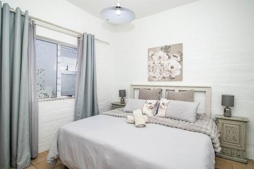 ein Schlafzimmer mit einem großen weißen Bett und einem Fenster in der Unterkunft Lieflappie❤ in Stilbaai