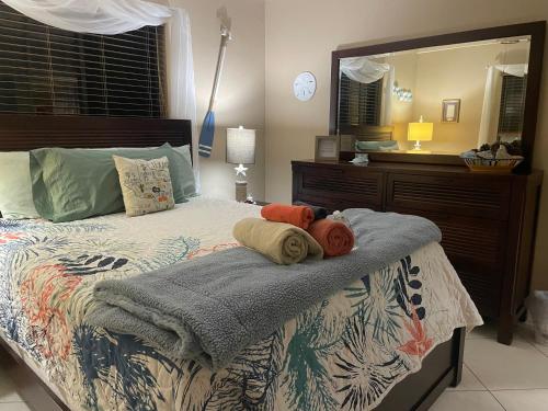 una camera da letto con letto, cuscini e specchio di Tropical Jungle Bugelow a Naples