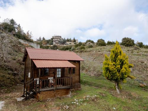 ein kleines Holzhaus auf einem Hügel mit einem Baum in der Unterkunft karion houses in Synikia Mesi Trikalon