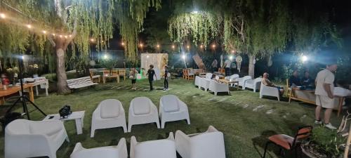 un ricevimento di nozze in un parco con sedie bianche e alberi di El Indio - Casa de campo a Villa del Salvador