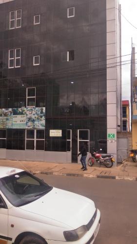 un'auto bianca parcheggiata davanti a un edificio di IGIKARI residence a Kigali