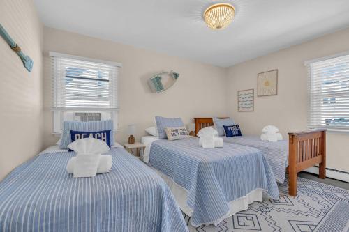 a bedroom with three beds with blue and white sheets at 209 4th Ave in Seaside Heights