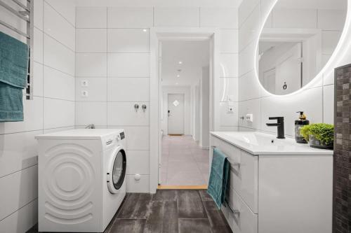 a white bathroom with a washing machine and a sink at Modern Seaside Cabin Tvedestrand Hantho Brygge in Tvedestrand