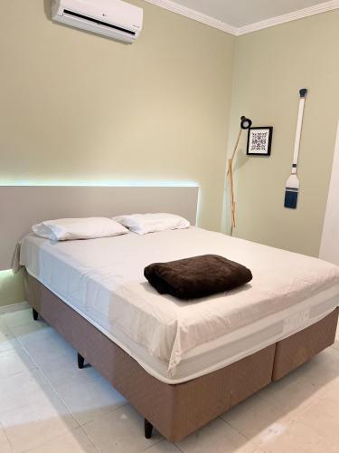 ein Bett mit einer braunen Decke darauf in einem Zimmer in der Unterkunft Bela Casa Em Caldas Novas in Caldas Novas