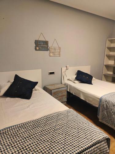 a bedroom with two beds and a shelf at Nuria's home in Calanda