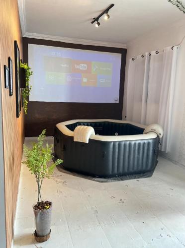 Eine große schwarze Badewanne stand vor einer Projektionsfläche. in der Unterkunft Bela Casa Em Caldas Novas in Caldas Novas