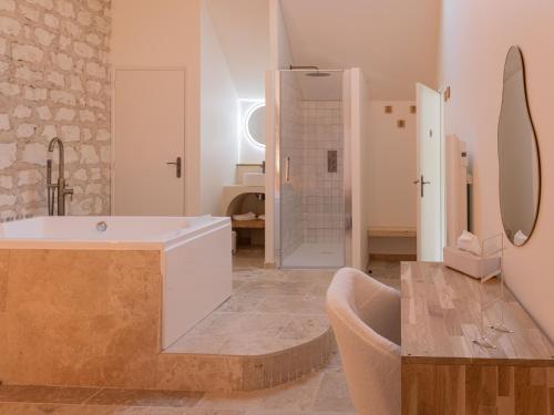 ein großes Badezimmer mit Badewanne und Waschbecken in der Unterkunft Suite avec balnéothérapie in Montholon