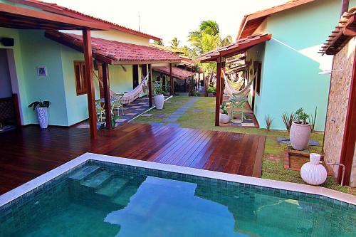 a swimming pool in front of a house at Pousada Jurará e Vila Jurará in Atins