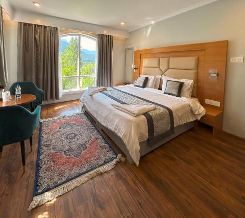 ein Schlafzimmer mit einem Bett und einem Tisch und einem Fenster in der Unterkunft Forest Hill Resorts in Pahalgām