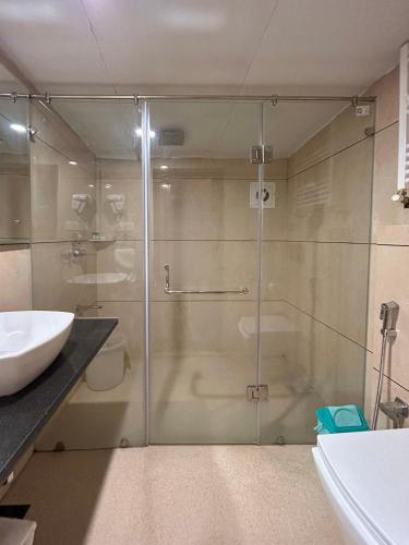 a bathroom with a glass shower and a sink at Forest Hill Resorts in Pahalgām