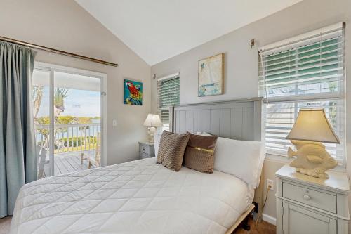 een slaapkamer met een wit bed en een balkon bij Jewel in the Sea in Duck Key