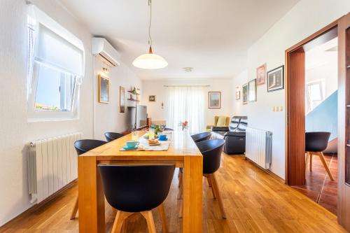 a kitchen and living room with a wooden table and chairs at Villa Dome in Slatine