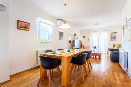 a kitchen and living room with a wooden table and chairs at Villa Dome in Slatine