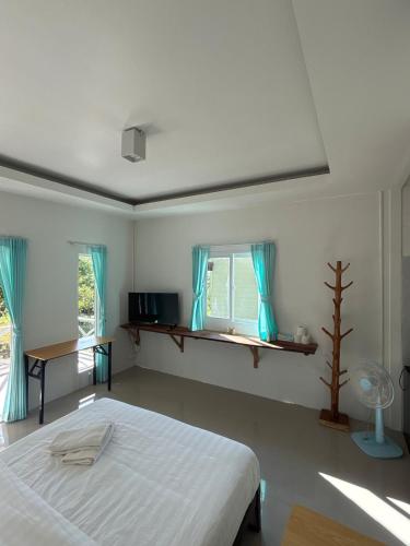 ein weißes Schlafzimmer mit einem Bett und einem Fenster in der Unterkunft Little Bailan Retreat - Jungle View in Ban Bang Bao