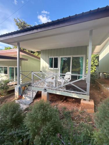 a porch of a house with two white chairs at Little Bailan Retreat - Jungle View in Ban Bang Bao