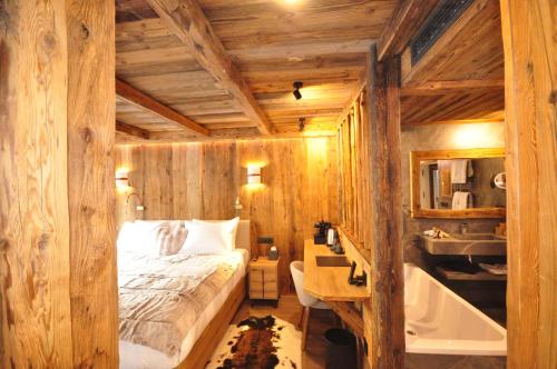 a bedroom with a bed and a sink and a tub at Hotel Vall d'Isard Suites in El Tarter