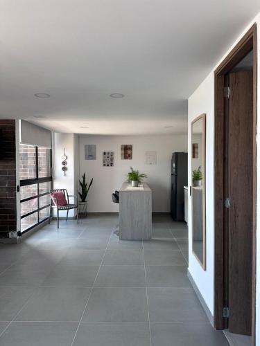 a room with a hallway with a table and a refrigerator at Sabaneta, aparta Loft, excelente Ubicacion, Wifi in Sabaneta