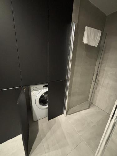 een wasmachine en droger in een kleine badkamer bij Apartmány Zlatý Potok in Zvolen