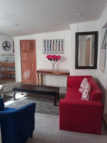 een woonkamer met een rode bank en een tafel bij Imany house in Kaapstad