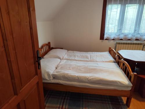 een slaapkamer met een bed, een tafel en een raam bij Chalúpka Paci in Ždiar