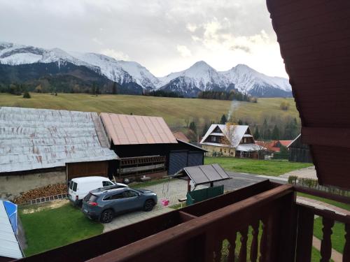 een auto geparkeerd voor een gebouw met bergen bij Chalúpka Paci in Ždiar