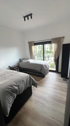 ein Schlafzimmer mit zwei Betten und einem großen Fenster in der Unterkunft Increíble casa con vista al lago in Licán Ray