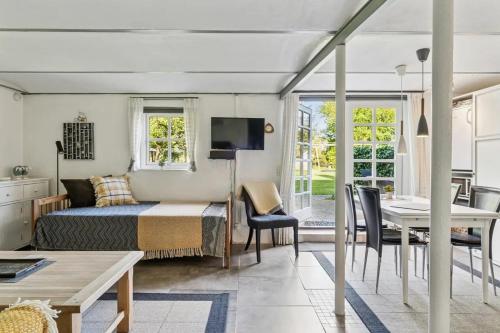 a bedroom with a bed and a dining room with a table at Skovboferie Apartments BB in Blåhøj Stationsby