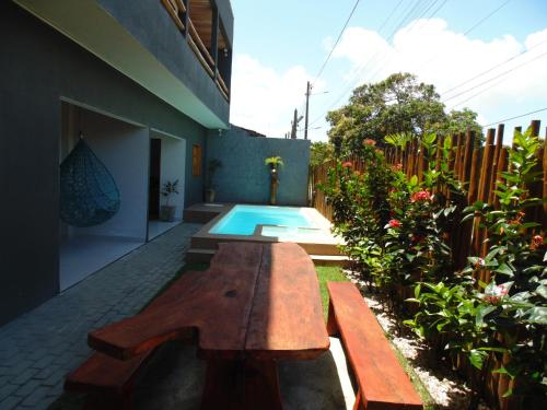 una panchina di legno seduta accanto alla piscina di Flats da Ilha Max Rev a Marechal Deodoro