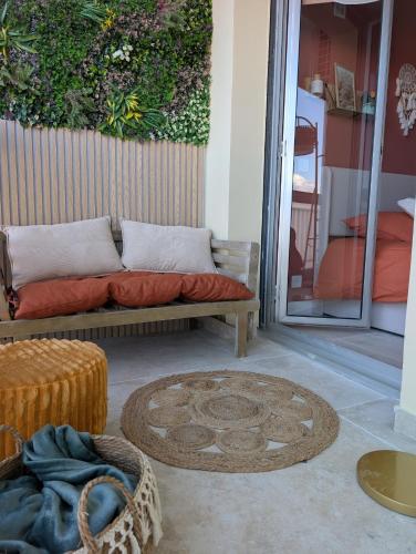 a couch sitting on a patio with a rug at T2 cosy proche de Nice - a 2 min à pied de la plage in Cagnes-sur-Mer
