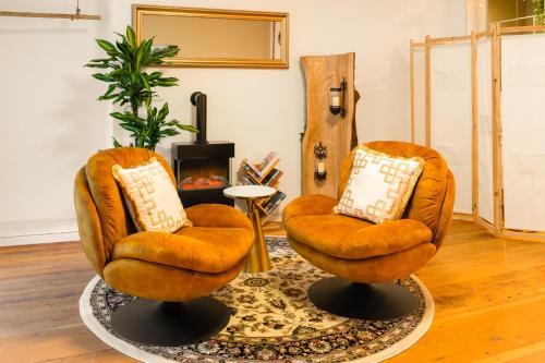 zwei orangefarbene Stühle im Wohnzimmer in der Unterkunft Leone Stays - Golden Castle Loft in Thun
