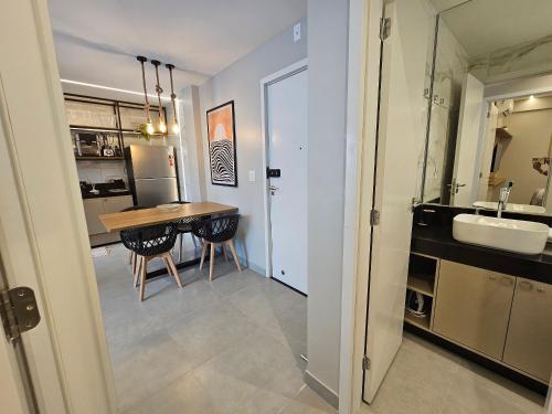 een keuken en eetkamer met een tafel en een spoelbak bij NOVO e Impecável • 1 Quarto • pertinho do LETREIRO in Tambaú