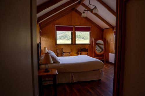 een slaapkamer met een groot bed en een raam bij Hotel Boutique 3 Pasos in Cerro Castillo