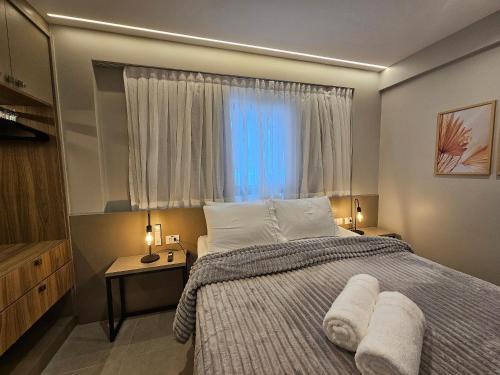 een slaapkamer met een bed en een raam met handdoeken bij NOVO e Impecável • 1 Quarto • pertinho do LETREIRO in Tambaú