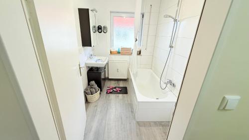 une salle de bain avec une baignoire, un lavabo et une douche dans l'établissement Apartment Unterkunft Baron, à Fürth