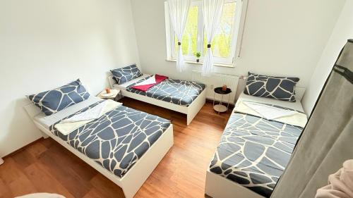 Cette chambre comprend trois lits et un canapé. dans l'établissement Apartment Unterkunft Baron, à Fürth