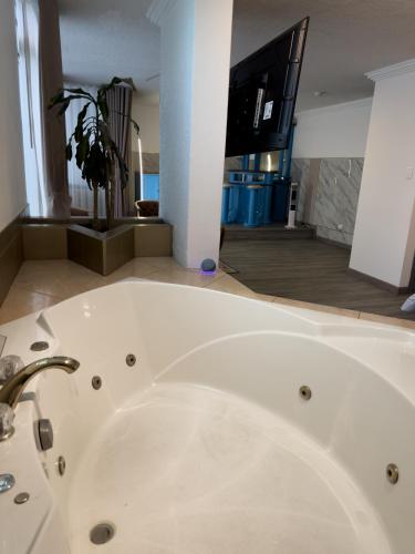 a white bath tub with a sink in a room at Hotel Bussines Center in Quito