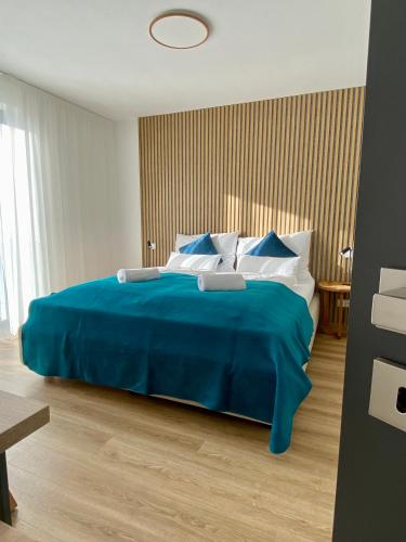 a bedroom with a large blue bed with blue sheets at Nad Soutokem in Volary