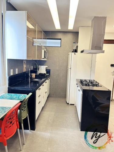 eine Küche mit einer schwarzen Theke und einem weißen Kühlschrank in der Unterkunft Maison Saint Remy 209 in Tambaú