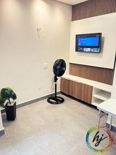 Ein Zimmer mit einem schwarzen Ventilator und einem Fernseher an der Wand in der Unterkunft Maison Saint Remy 209 in Tambaú