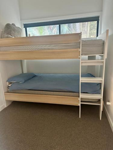 a bunk bed in a room with a window at Bundeena Bungalow in Bundeena
