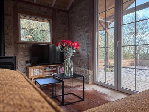 een woonkamer met een vaas met bloemen op een tafel bij Idyllic cottage with wellness facilities in Alveringem