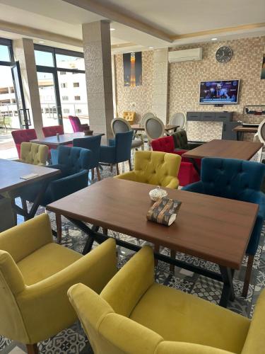 a waiting room with tables and chairs and a fireplace at New Sirius Otel in Seyhan
