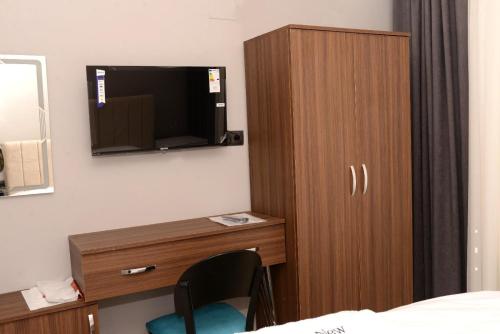 SeyhanNew Sirius Otel的酒店房间里有一台电视和一个木制橱柜