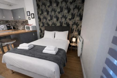 a small bedroom with a bed and a kitchen at Le Fidji / 100m Gare in Tours
