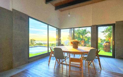 una sala da pranzo con tavolo e sedie e una grande finestra di Blackhouse jacuzzi piscina a Pontevedra