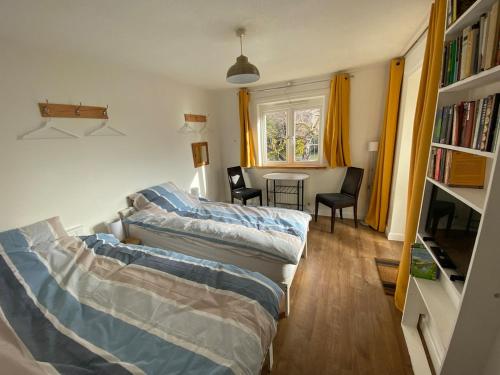 a living room with two beds and a tv at Thames Side Flat in Oxford