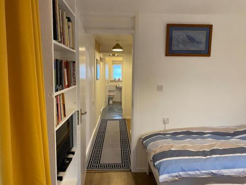 a bedroom with a bed and a book shelf at Thames Side Flat in Oxford
